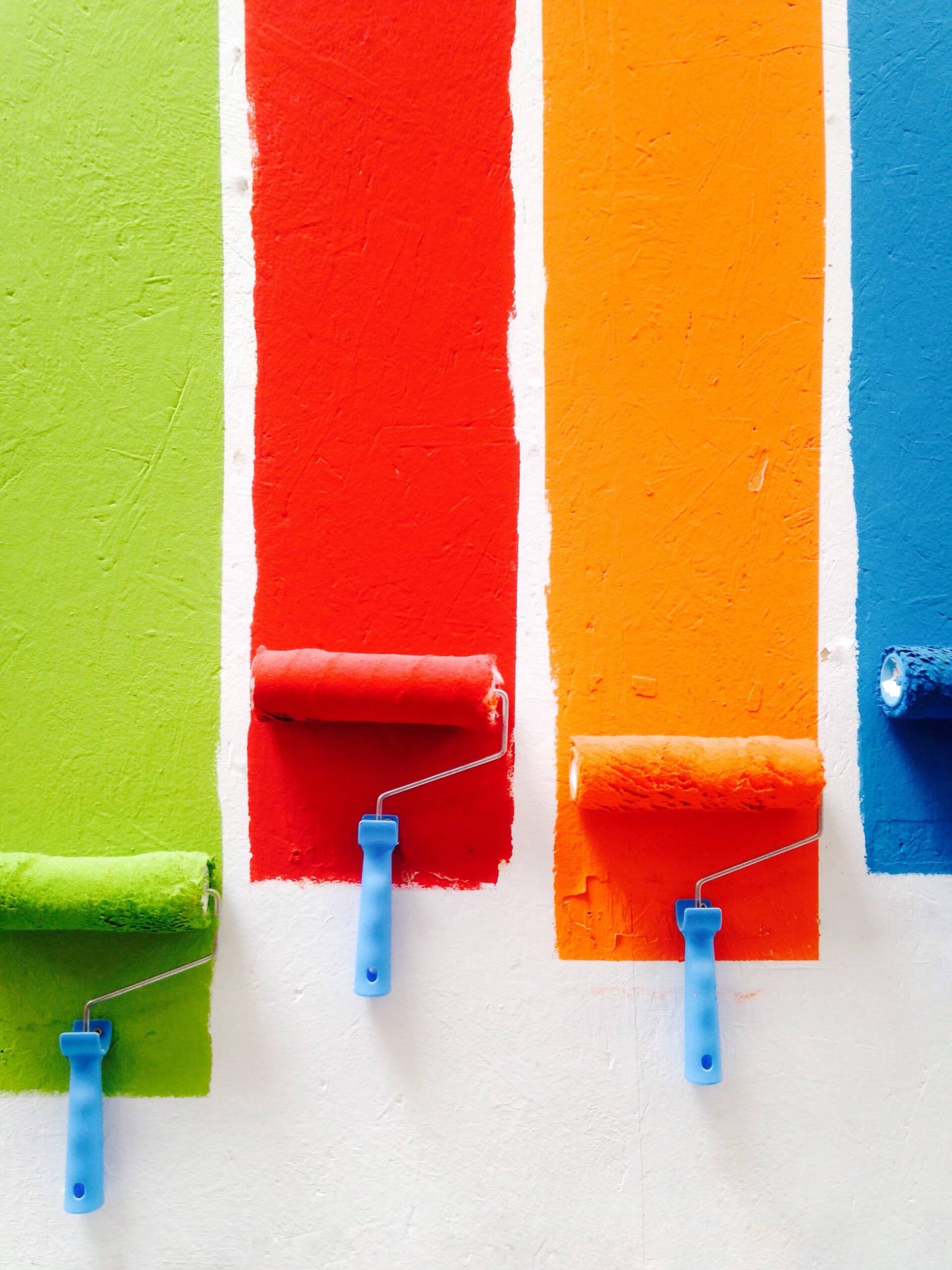 Paint rollers with fresh stripes of exterior paint colors