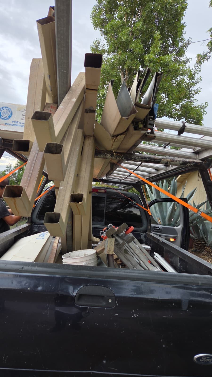 Old gutters and downspouts loaded in a truck for haul-away