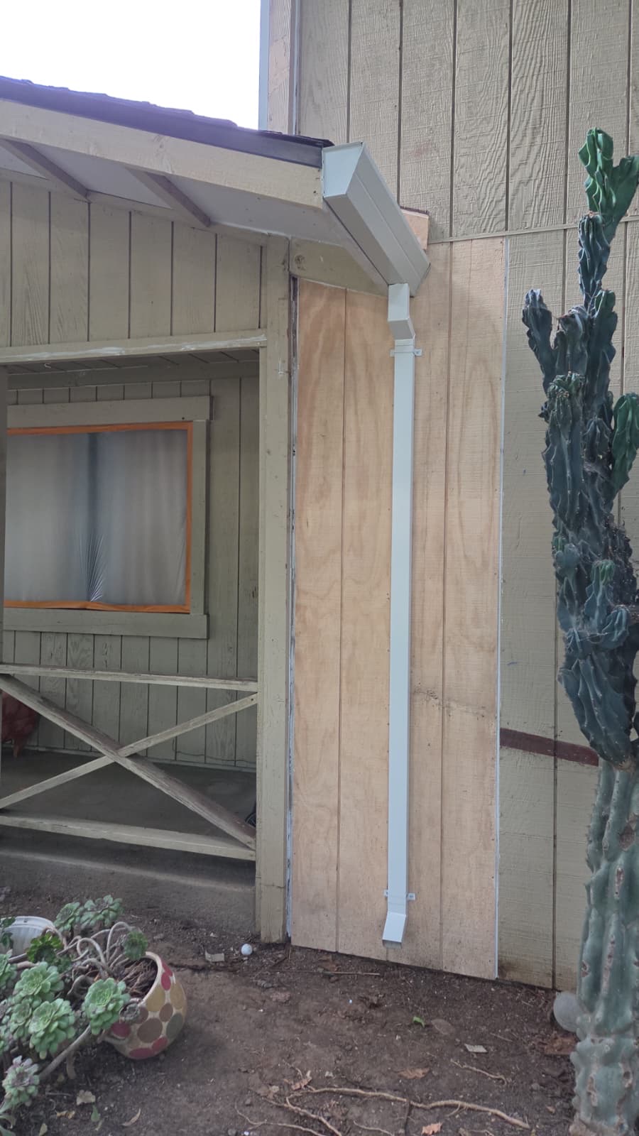Replaced siding panels and a new white downspout before painting