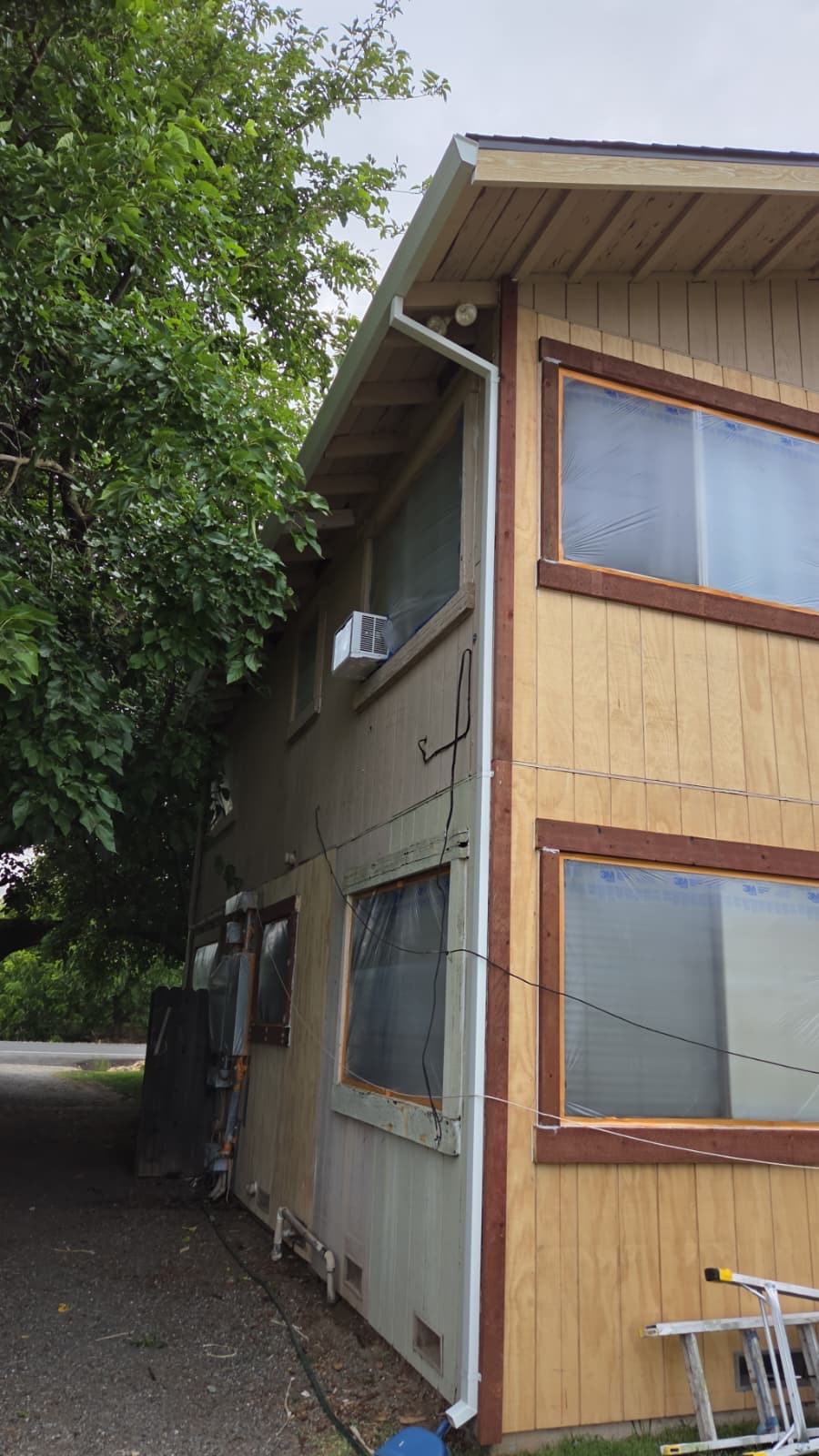Side of the Vacaville house with faded siding and brown trim before painting